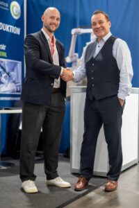 Norman Wahl (DOBOT EMEA) und Jan Kermer (Cobomatics) – all about automation Chemnitz 2026 Norman Wahl (DOBOT EMEA) und Jan Kermer (Cobomatics) beim Handschlag am Cobomatics-Messestand, all about automation Chemnitz 2026